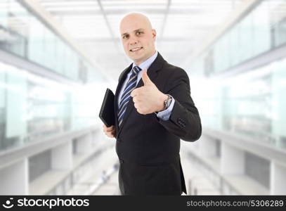 proud businessman with a tablet pc going thumb up, at the office