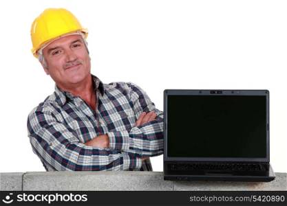 proud mason posing next to his laptop