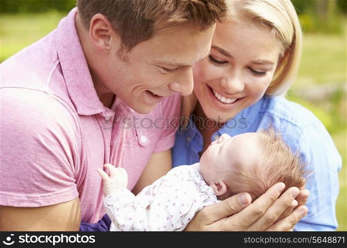 Proud Parents Holding Baby Daughter In Garden