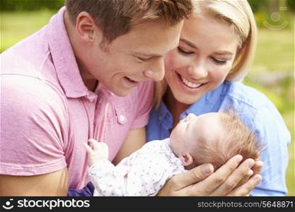 Proud Parents Holding Baby Daughter In Garden
