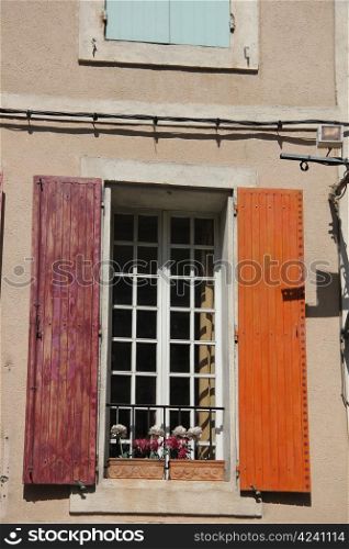Provencal style window with painted wooden shutters