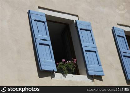 Provencal style window with painted wooden shutters