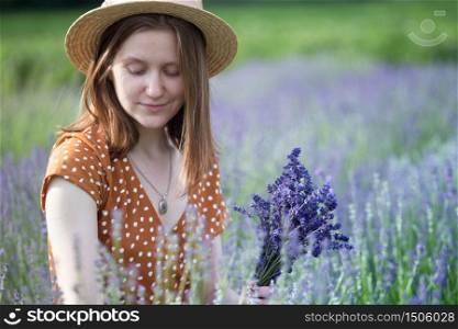 Provence - girl in a hat collects a bouquet of lavender. France