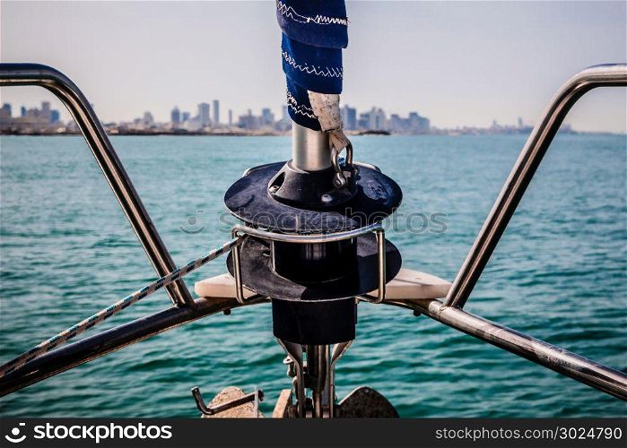 Prow of a sailboat. In the background there are buildings of Tel Aviv, Israel.