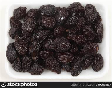 Prunes in a supermarket tray from above
