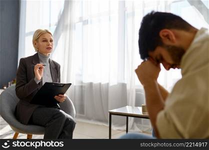 Psychologist consulting talking to depressed frustrated unhappy man. Psychotherapy help session. Psychologist talking to depressed frustrated unhappy man