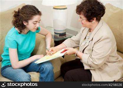 Psychologist giving a teen girl an agreement to sign before starting therapy.