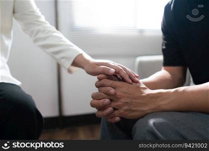 Psychologist woman touching hands to encouraging man with mental health problem in therapy center.