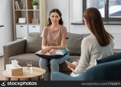 psychology, mental therapy and people concept - young woman patient and woman psychologist at psychotherapy session. woman and psychologist at psychotherapy session