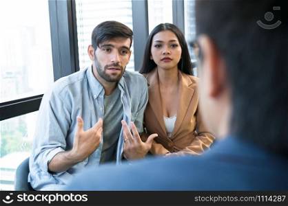 Psychotherapist inquiring about symptoms occurring within mind from patients with mental health problems in hospital. Group psychotherapy for support and helping worried man to change negative mindset