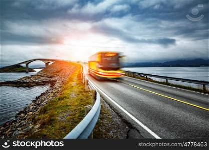 "Public bus traveling on the road in Norway. Public bus in motion blur. Atlantic Ocean Road or the Atlantic Road (Atlanterhavsveien) been awarded the title as "Norwegian Construction of the Century"."