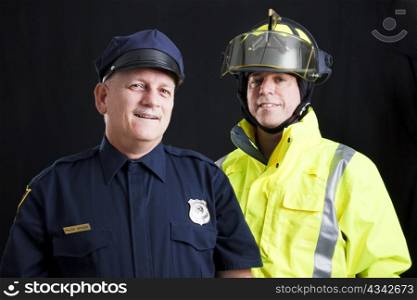 Public employees, a firefighter and a police officer, smiling and happy. Black background.