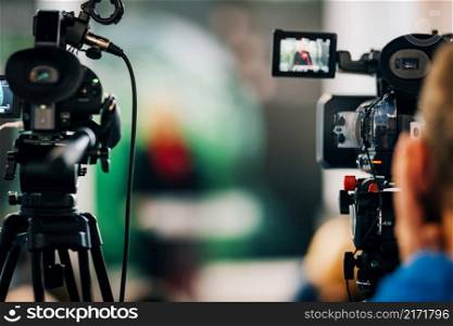 Public live event media coverage, television cameras at a press conference. Public Live Event Television Coverage