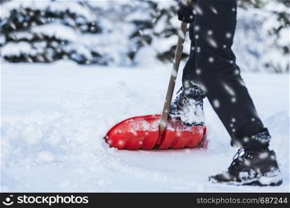 Public service worker or citizen shoveling snow during heavy winter blizzard