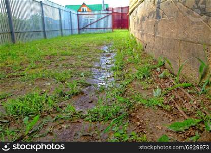 puddles after rain near the wall of a wooden house. puddles after rain near the wall of a wooden house, Russia