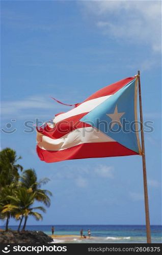 Puerto Rican flag fluttering on the beach, Luquillo Beach, Puerto Rico