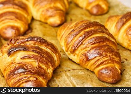 Puff pastry croissants with chocolate on baking sheet. Homemade cooking. Concept of international cuisine. Delicious buttery croissants removed from the oven on a baking sheet. Concept of homemade pastry. Italian or french traditional breakfast