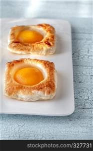 Puff pastry with canned peaches on the wooden table
