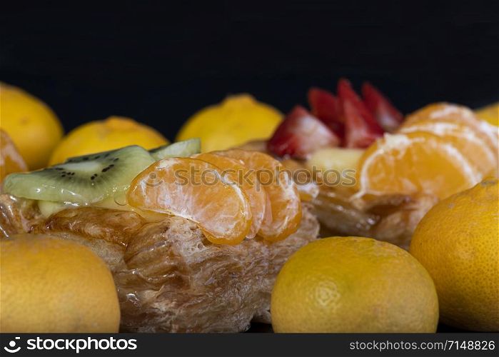 puff pastry with tangerine fruit on black background