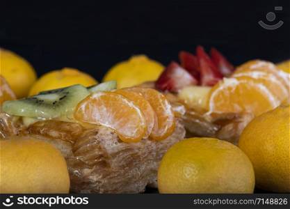 puff pastry with tangerine fruit on black background