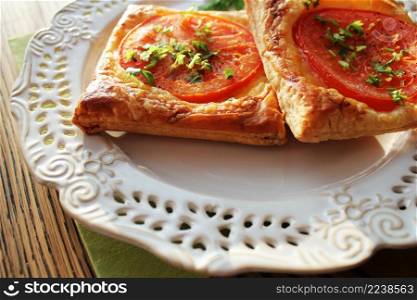 Puff-pizza with mozzarella cheese, tomatoes on table.. Puff-pizza with mozzarella cheese, tomatoes on plate