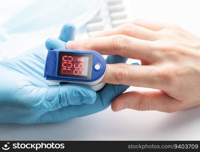 Pulse oximeter measuring oxygen saturation in blood and heart rate.  Pulse oximeter on the patient&rsquo;s hand