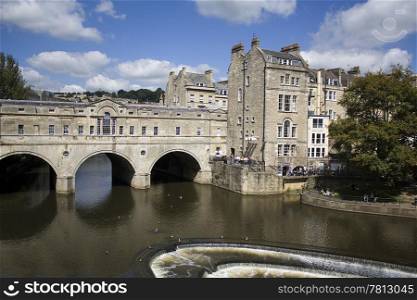 Pulteney Bridge in Bath, England. Pulteney Bridge over the river Avon in Bath, England. It is lined with shops on both sides. Georgian architecture.