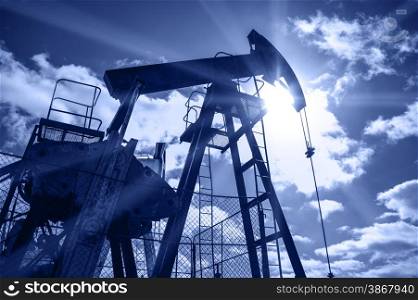 Pump jack. Extraction of oil. Toned blue.. Oil rig.