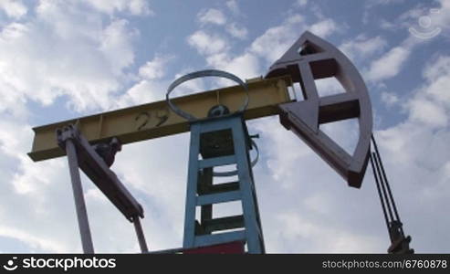 Pump jack lifting oil from well to the surface - iconic symbol of oilfield