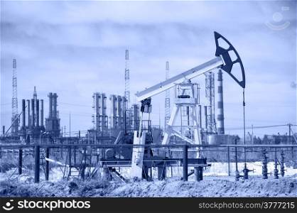 Pump jack on a background of petrochemical plant. Oil and gas industry.