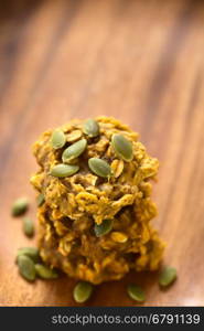 Pumpkin and oatmeal drop cookies with pumpkin seeds on top, photographed with natural light (Selective Focus, Focus one third onto the top cookie)