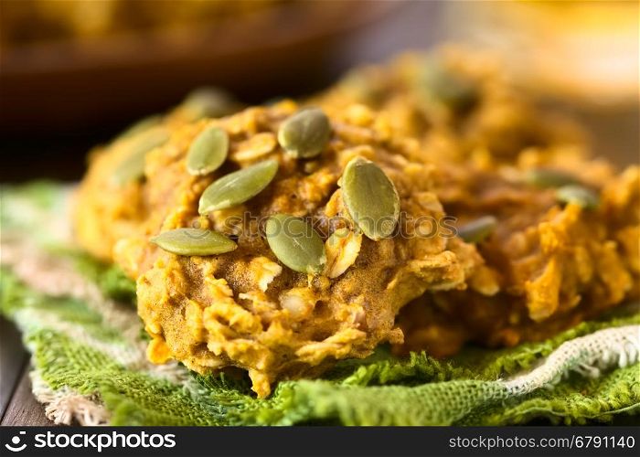 Pumpkin and oatmeal drop cookies with pumpkin seeds on top, photographed with natural light (Selective Focus, Focus one third into the first cookie)