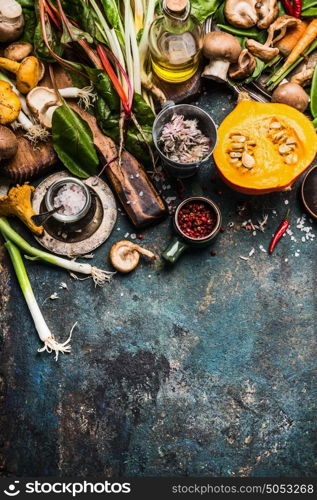 Pumpkin and Other autumn vegetables and seasoning ingredients for seasonal cooking on rustic kitchen table background , top view, place for text