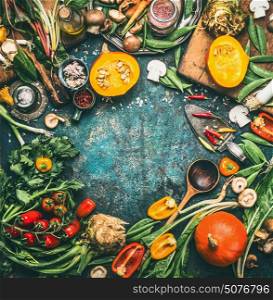 Pumpkin and Others organic harvest vegetables and ingredients with cooking spoon on rustic background, top view, frame