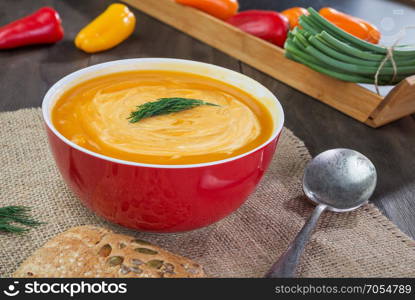 Pumpkin and sweet potatoes soup with sour cream ,dill and pumpkin bread on dark wooden table