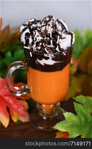Pumpkin chocolate beverage with whipped cream and chocolate topping