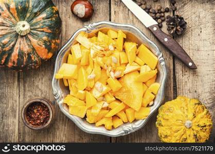 Pumpkin cut in a pieces and food ingredients.Autumn seasonal cooking concept. Pumpkin and ingredients for cooking