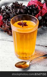 pumpkin jelly drink with anise in the background with wreath of fir cones in autumn. pumpkin jelly drink