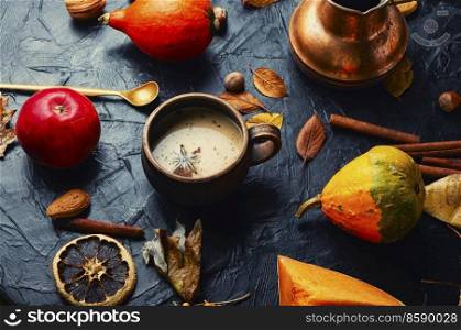 Pumpkin latte or coffee on an autumn background. Delicious pumpkin latte