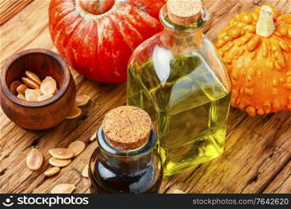 Pumpkin oil in bottle,raw pumpkin and pumpkin seeds.Autumn food. Pumpkin seed oil