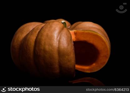pumpkin on a black glossy surface with a cut-out part