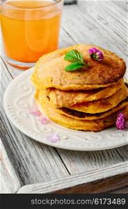 pumpkin pancakes and glass of juice on the tray. pancakes with pumpkin