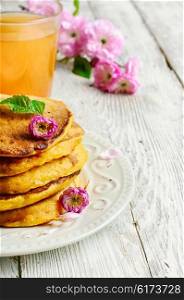 pumpkin pancakes with light dishes and glass of juice. pancakes with pumpkin