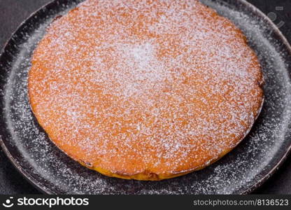 Pumpkin pie with whipped cream and cinnamon on a dark background, top view. Pumpkin pie, tart made for Thanksgiving day with whipped cream on a black plate