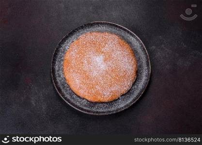 Pumpkin pie with whipped cream and cinnamon on a dark background, top view. Pumpkin pie, tart made for Thanksgiving day with whipped cream on a black plate