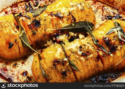 Pumpkin roasted with sage, thyme and garlic. Pumpkin baked with herbs.Food background. Baked pumpkin with herbs, close up