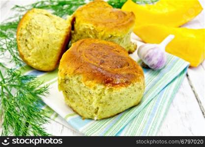 Pumpkin Scones with garlic and dill on a green towel, yellow pumpkin slices on the background of wooden boards