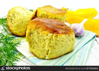 Pumpkin Scones with garlic and dill on a towel, yellow pumpkin slices on the background of wooden boards