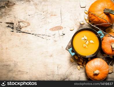 Pumpkin soup. Cooked soup from a ripe pumpkin. On wooden background.. Cooked soup from a ripe pumpkin.