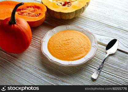 Pumpkin soup cream on a wooden table and ingredients
